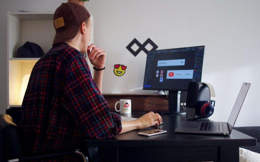 Web developer working at a desk with two screens